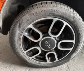 Fiat 500 wheel with a black alloy rim and Continental tire, 195/55R15 size, visible around the brake area