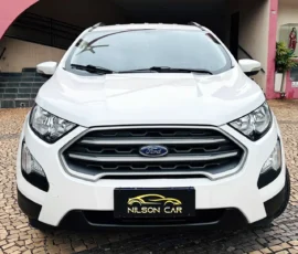 Front view of a white Ford SUV parked on a cobblestone driveway, with a Nilson Car license plate visible under the grille.