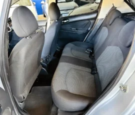 Interior view of a compact car showing gray cloth rear seats with headrests and a door panel on the right side
