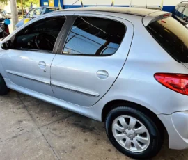 Silver hatchback car parked indoors at a dealership, showing the passenger side with rear and side doors visible.