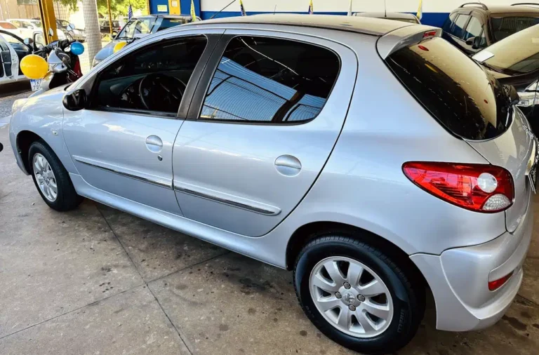 Silver hatchback car parked indoors at a dealership, showing the passenger side with rear and side doors visible.