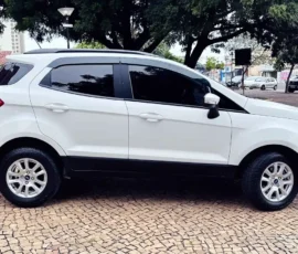 White compact SUV with a mounted spare tire on the rear, parked on a patterned cobblestone surface with dark tinted windows.