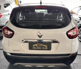 Rear view of a white Renault Captur with a Nilson Car dealer plate frame, red taillights, and a dark rear window.