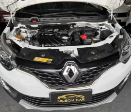 Front view of a white Renault with the hood open, exposing the engine bay and battery.