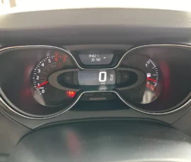 Car dashboard instrument cluster: digital speed readout shows 0 km/h, tachometer left, fuel gauge right, and warning lights illuminated.