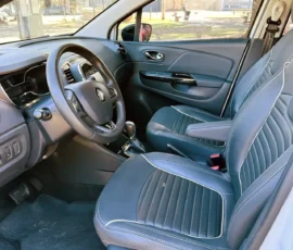 Front interior of a car with blue stitched seats, steering wheel, and center console visible.