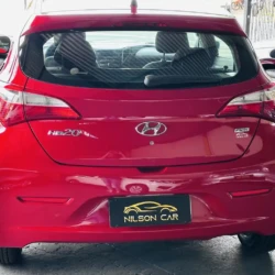 Rear view of a red Hyundai HB20 hatchback, showing the Hyundai logo and a Nilson Car dealer plate on the bumper.