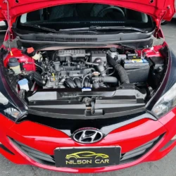 Red Hyundai with hood up, exposing the car’s engine bay and battery visible from above