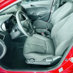 Front interior of a red car showing the driver and passenger seats, steering wheel, and dashboard.