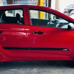 Red compact hatchback parked on a street, side profile with visible HB20 badge on the door rail area—focus on the car’s shape and color.