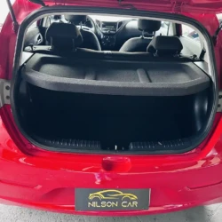 Open trunk of a red hatchback showing an empty cargo area with a black cargo cover in place.