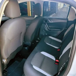 Back seat of a compact car with gray and black fabric seats, red seatbelt buckles, and an open rear door showing the door panel.