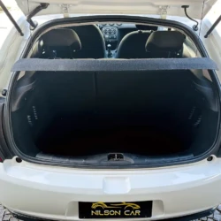 Open white hatchback trunk with cargo area clear, rear seats visible and parcel shelf in place, dealership plate reading Nilson Car